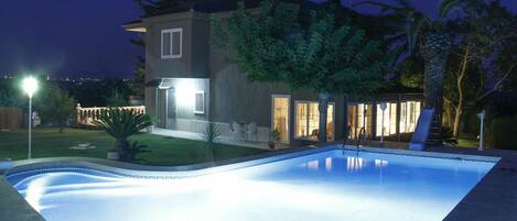 Una piscina con borde transparente, rodeada de un área pavimentada.