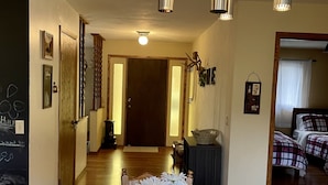 A dining area with a wooden table, two placemats, a metal vase with white flowers, and a chandelier with spherical glass bulbs. - Country home with no pet fees!!  (Hillsboro)