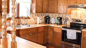 A kitchen with wooden cabinets, a stainless steel stove, and a wooden island with a sink. - Country home with no pet fees!!  (Hillsboro)