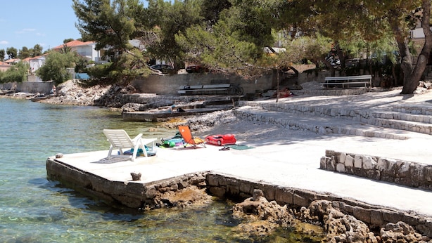 A pier with clear water, a bench, and a small boat. - A 4 apt w big terrace, sea view & close to beach (Arbanija)
