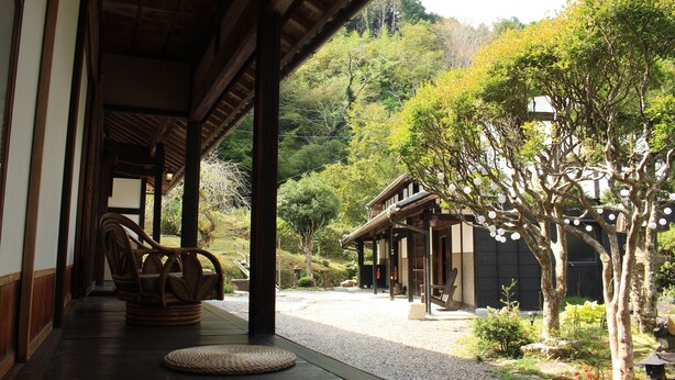 A traditional Japanese building with a wooden exterior and a covered walkway. - The Ninja Mansion (Toyota)