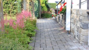 A paved pathway flanked by greenery and a stone wall. - Däschinger Holiday Apartment -Goldener Mond- in Mastershausen – Hunsrück Getaway for 6 Guests (Mastershausen)