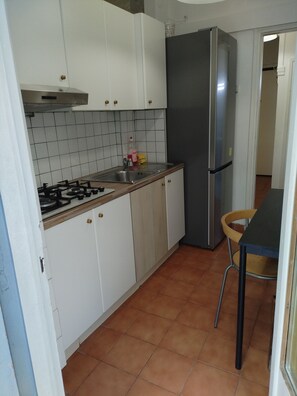 Kylskåp, mikrovågsugn, spishäll och grytor/köksredskap
