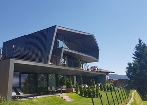 A modern two-story house with a balcony, a staircase leading to the entrance, and a well-maintained lawn. - Apartment 'Mut Residenze Moritz' Close to Merano with Mountain View and Wi-Fi (Avelengo)