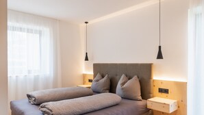 Une chambre à coucher moderne avec un lit, des tables de chevet et une commode.