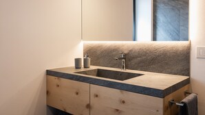 Une salle de bain moderne avec un meuble-lavabo en bois, un double vasque et un grand miroir.