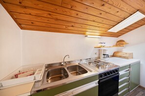 Une cuisine équipée d’un évier à deux bacs, d’une cuisinière et d’un four à micro-ondes.