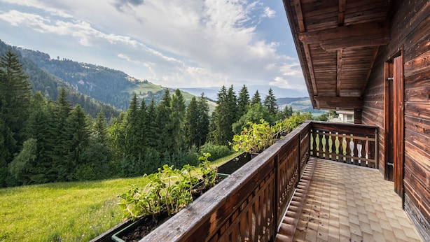 A wooden balcony with a view of a forested valley and distant mountains. - Holiday Apartment "Grödnerhof - Almöhi" Mountain View, Wi-Fi, Garden & Balcony (Breien / Tiers)