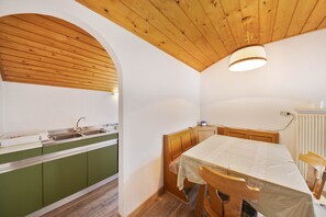 Eine Küche mit Holzausstattung, einem Spülbecken und einem Tisch mit Stühlen.