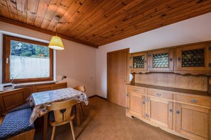 A wooden interior with a dining table, bench, and cabinets.