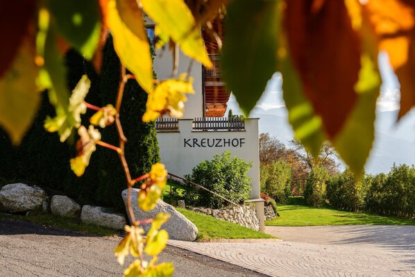 A building with a sign reading 'KREUZHOF' in front of a paved path.