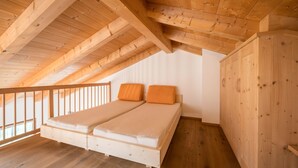 A room with a wooden ceiling, a bed with two pillows, and a wooden wardrobe. - Apartment "Kreuzhof rechts" with Mountain View, Wi-Fi, Balcony & Garden (Neustift)