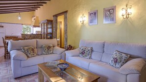 Ein Wohnzimmer mit zwei Sofas, einem Couchtisch und einer Steinsäule.