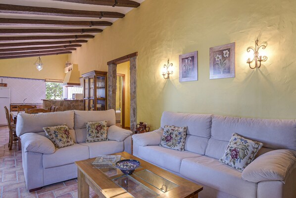 A living room with two sofas, a coffee table, and a stone pillar.