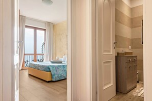 A bedroom with a bed, a dresser, and a balcony. - Charming Apartment “Bel Soggiorno 1” with Lake and Mountain View, Wi-Fi & Balcony; Parking (Voltino di Tremosine)