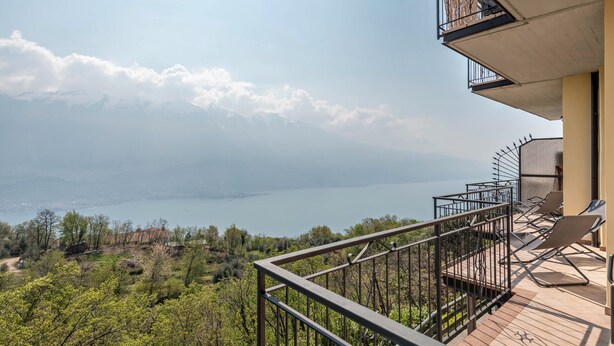 A balcony with a view of a lake and mountains.