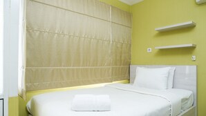 A hotel room with a bed, a headboard, and a wall-mounted shelf. - OYO 3691 Apartment Saladin Mansion (Depok)