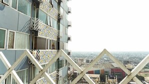 A high-rise building with patterned balconies and a cityscape view. - OYO 3691 Apartment Saladin Mansion (Depok)
