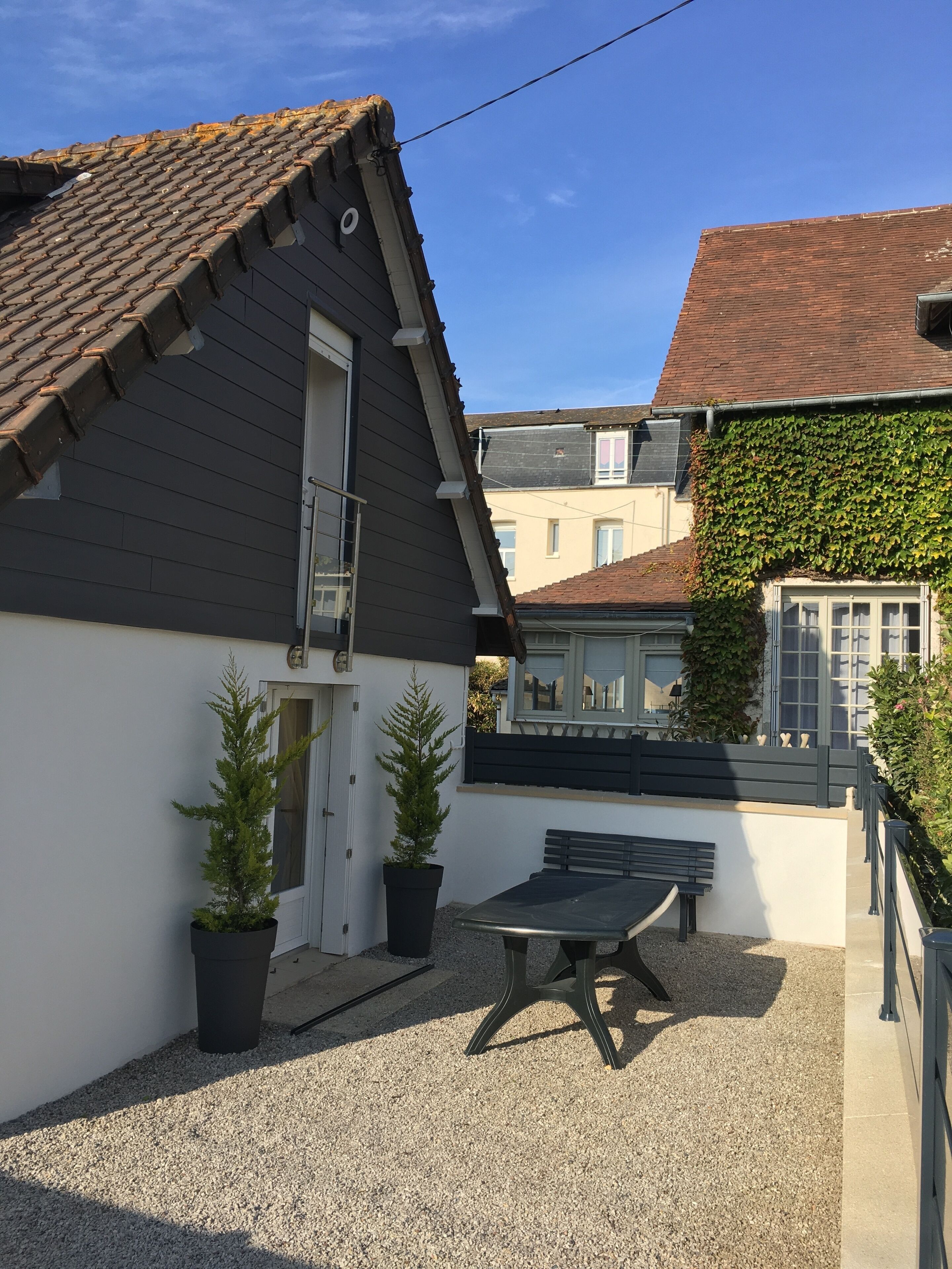 Ein Innenhof mit Kiesboden, einer Bank und zwei Blumentöpfen.