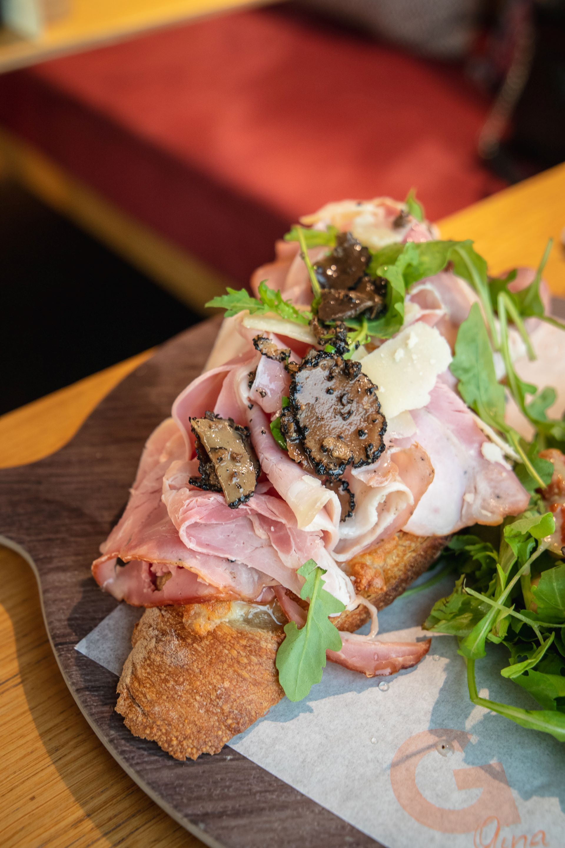 Un panino farcito con diversi ingredienti, su un tagliere di legno.