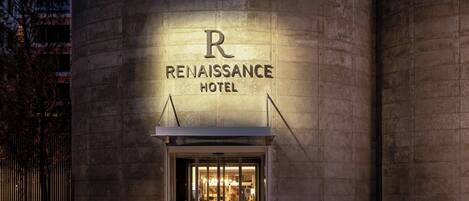 The exterior of the Renaissance Hotel with a prominent 'R' logo and the name 'Renaissance Hotel' displayed above the entrance.