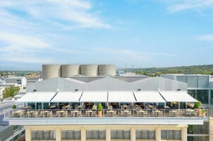 Una terraza en la azotea con mobiliario exterior y vistas a la ciudad.