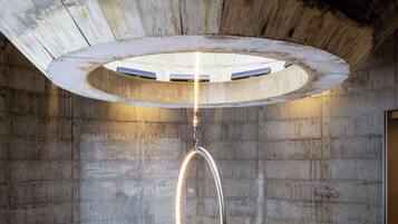 Una habitación circular con un sillón colgante y una lámpara en el techo.