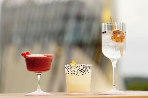 Tres cócteles diferentes en vasos sobre una mesa.
