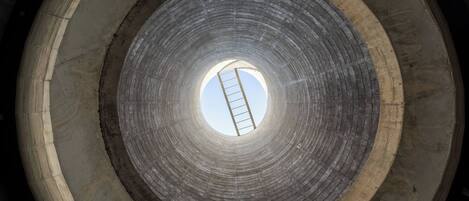 A circular concrete structure with a ladder leading to the center.