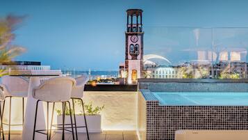 Enjoy breathtaking city views from this rooftop terrace featuring a modern pool and comfortable seating area.