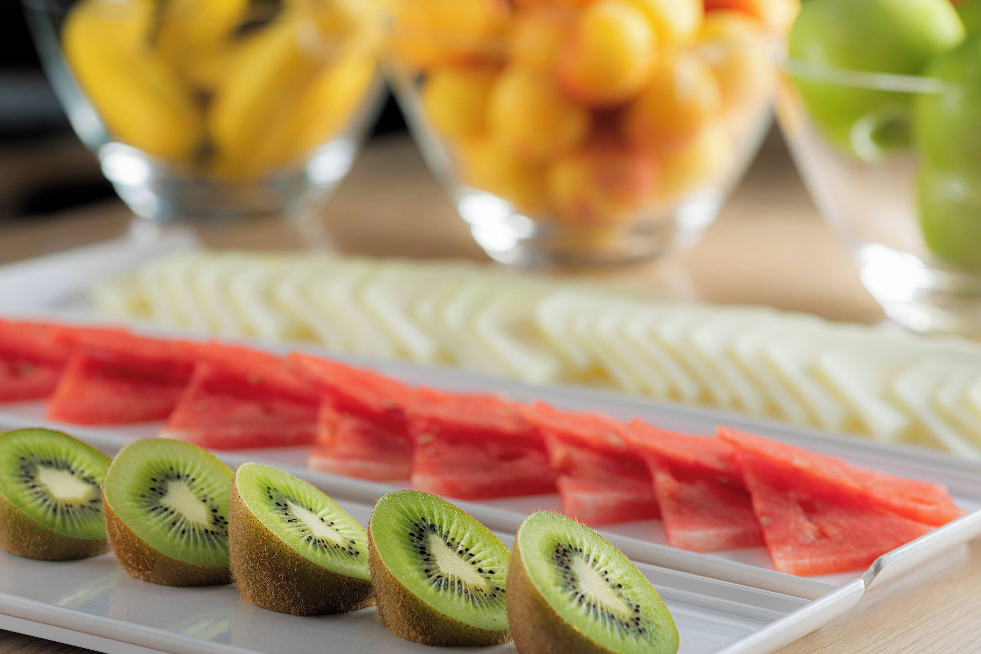 A fruit platter with sliced kiwi, watermelon, and other fruits.