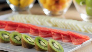 Una bandeja de frutas con kiwi en rodajas, sandía y otras frutas.