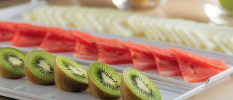 A fruit platter with sliced kiwi, watermelon, and other fruits.