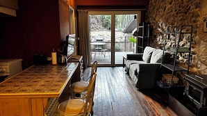 Una habitación acogedora con una mesa de madera, sillas, un sofá y una chimenea.