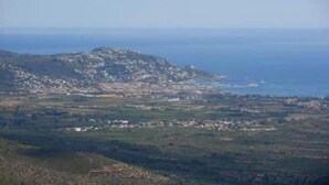 Un pueblo costero con una colina destacada, casas y vistas al mar.