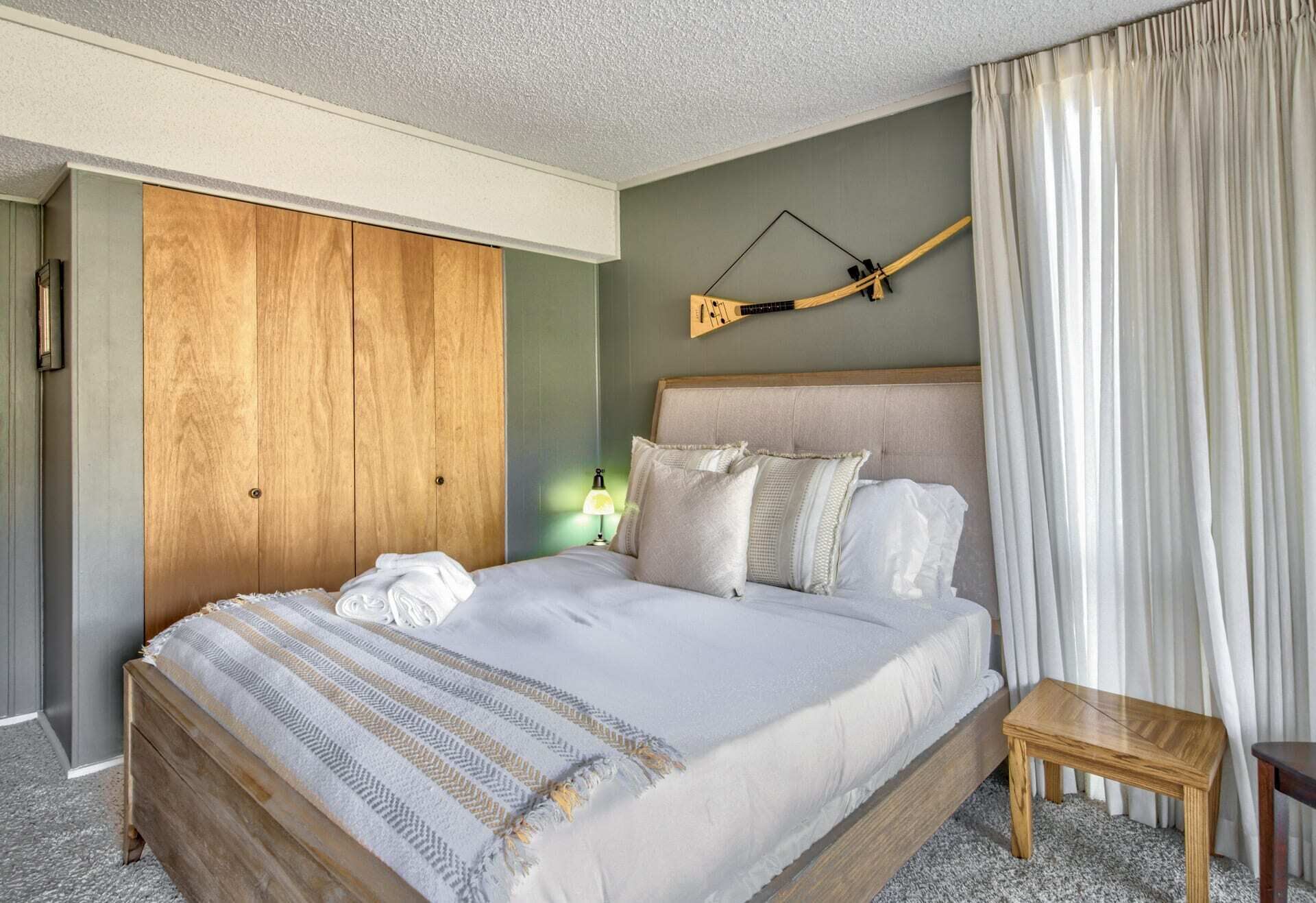 Ein Hotelzimmer mit einem großen Bett, einem Holzschrank und einem kleinen Holztisch.
