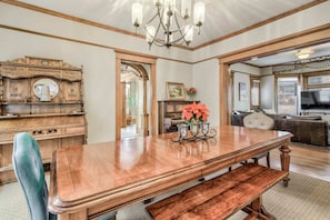 A spacious dining area with a wooden table, benches, and a chandelier. - 8brdowntownpool Table & Mini Golffoosball (Colorado Springs)