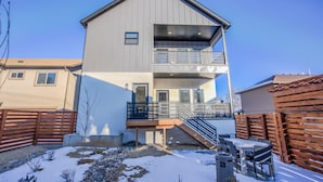 A two-story building with a balcony, a covered outdoor seating area, and a snow-covered ground. - 2bdmodern Garden Level-perfectoff Downtown Area (Colorado Springs)