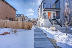 A residential area with a snow-covered sidewalk, a wooden fence, and houses with modern architecture. - 2bdmodern Garden Level-perfectoff Downtown Area (Colorado Springs)