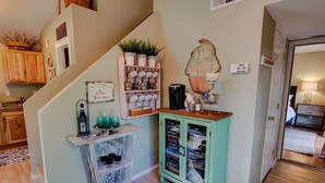 A staircase with a wooden finish, a green cabinet with glass doors, and a wall-mounted coffee station. - 2BD Chic Cottage Mtns Walk Everywhere (Colorado Springs)