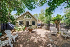 A house with a patio area featuring outdoor furniture, a fountain, and a garden.