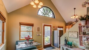 A kitchen with a dining area, a refrigerator, a sink, and a window with a view of the outside. - 2BD Chic Cottage Mtns Walk Everywhere (Colorado Springs)