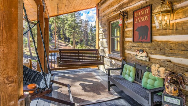 A wooden cabin with a porch, a bench, and a 'DO NOT ANNOY' sign. - Mountain Getaway Cabinhot Tub & Pool Table4bd (Cascade)