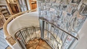 A spiral staircase with a stone wall and metal railing. - Mountain Getaway Cabinhot Tub & Pool Table4bd (Cascade)