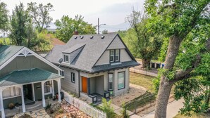 A two-story house with a stone pathway leading to the front door, surrounded by a white picket fence and a small garden area. - 3BD Downtown Modern Victorian W/hot Tub, Park & Lake! (Colorado Springs)