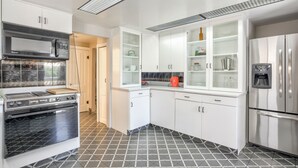 A modern kitchen with white cabinets, stainless steel appliances, and a black and white tiled floor. - Modern&chic Cottage1bdcomfy Home In Old Colorado (Colorado Springs)