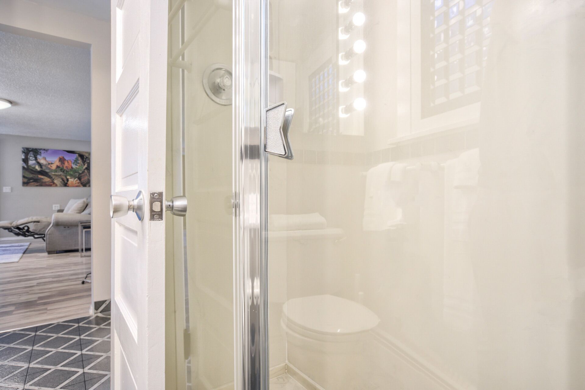 A modern bathroom with a glass shower enclosure, a toilet, and a sink.
