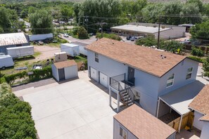 A two-story building with a flat roof, a small attached garage, and a covered outdoor area.