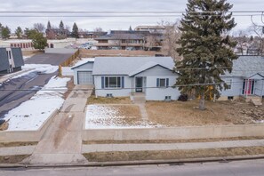 A residential house with a garage, a driveway, and a large tree in front. - 4 Bedroom with Grill (Colorado Springs)