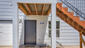 A house entrance with a wooden staircase, a garage door, and a welcome mat. - 1brmodern & Chicdowntown OCC (Colorado Springs)